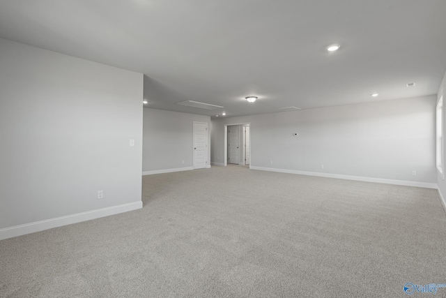 spare room featuring light colored carpet, baseboards, and recessed lighting