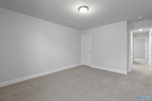 carpeted empty room featuring baseboards and visible vents