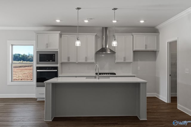 kitchen with wall chimney range hood, light countertops, a kitchen island with sink, black oven, and built in microwave