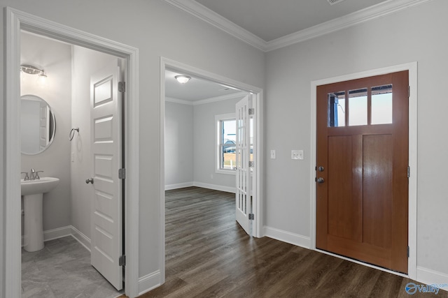 foyer entrance with wood finished floors, baseboards, and ornamental molding