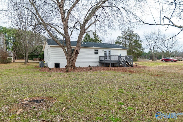 rear view of house with a yard and a deck