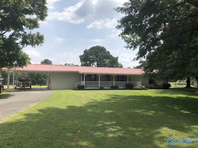 ranch-style house with aphalt driveway, an attached carport, metal roof, a porch, and a front lawn