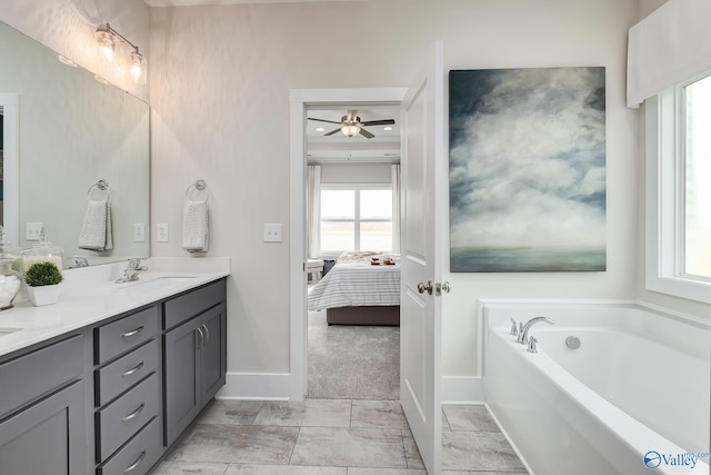 bathroom featuring a tub, vanity, ceiling fan, and a healthy amount of sunlight