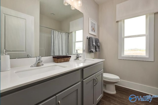 bathroom with hardwood / wood-style floors, curtained shower, vanity, and toilet