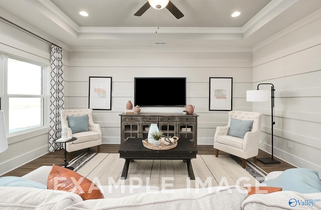 living room with hardwood / wood-style flooring, plenty of natural light, and a raised ceiling