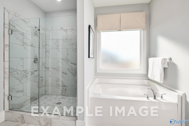 bathroom featuring shower with separate bathtub