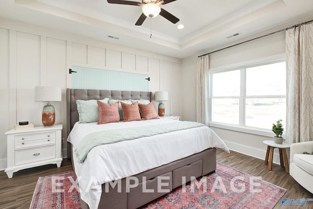 bedroom featuring dark hardwood / wood-style floors, ceiling fan, and a raised ceiling