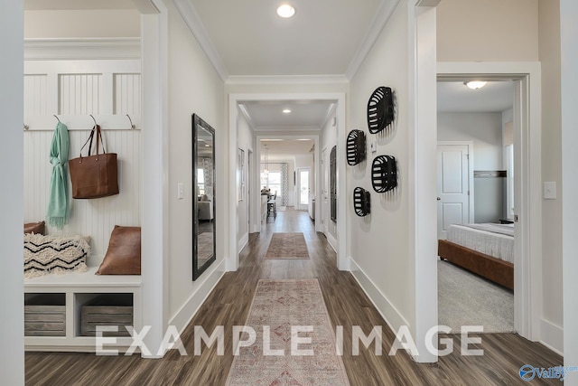 hallway with ornamental molding and dark hardwood / wood-style flooring