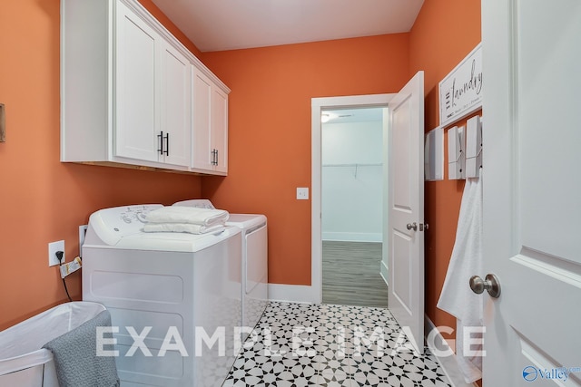 washroom with washer and dryer and cabinets