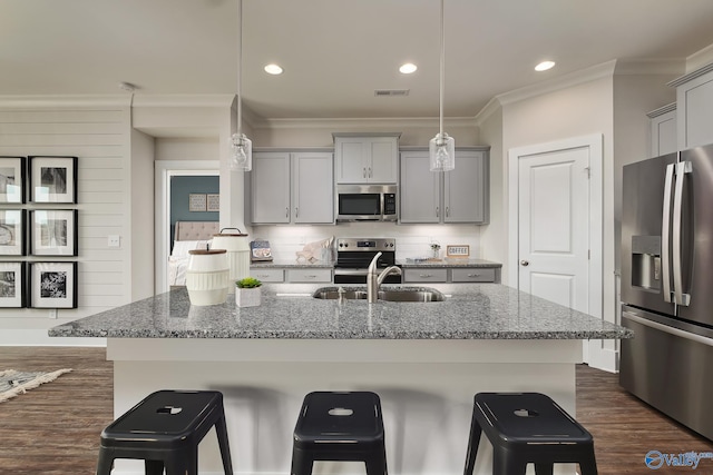 kitchen with gray cabinets, appliances with stainless steel finishes, stone countertops, and hanging light fixtures