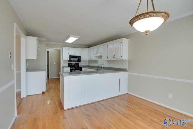 kitchen featuring black appliances, ornamental molding, light wood-style floors, and a sink