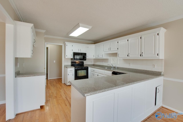 kitchen with light wood finished floors, white cabinets, a sink, a peninsula, and black appliances