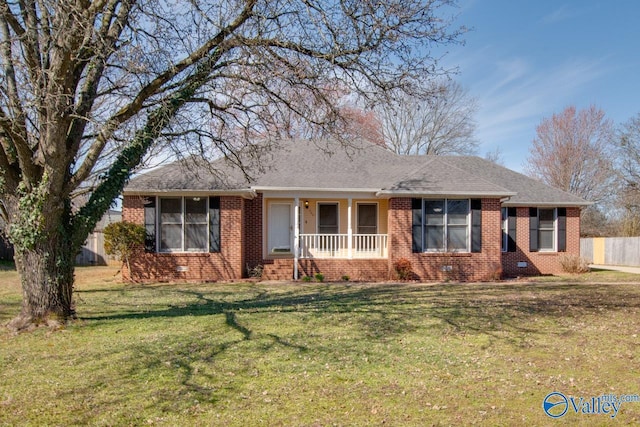 ranch-style home with a shingled roof, fence, a front lawn, a porch, and brick siding