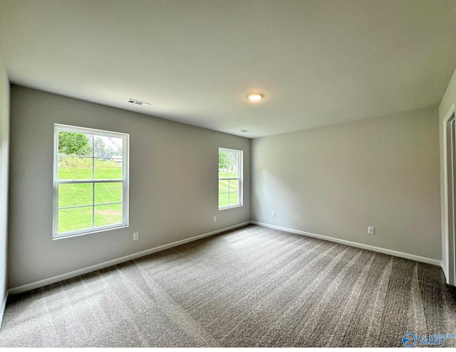 carpeted empty room featuring visible vents and baseboards