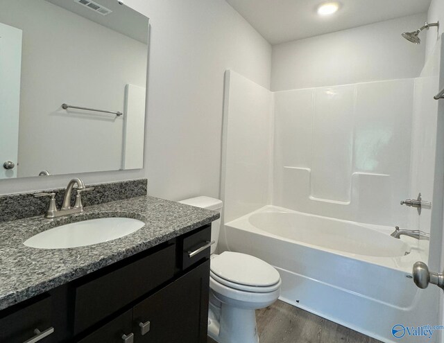 full bathroom featuring toilet, shower / bathtub combination, wood-type flooring, and vanity