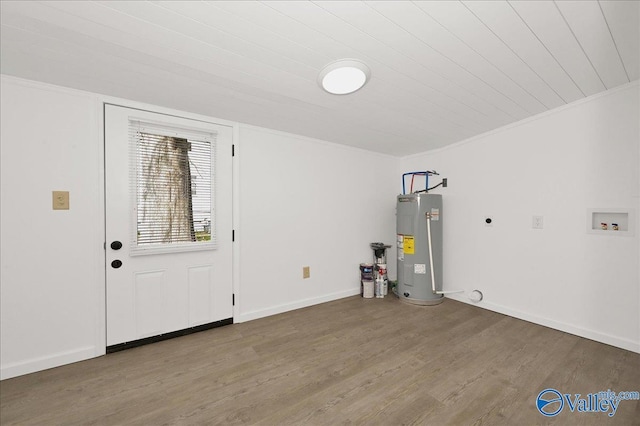 interior space with water heater, ornamental molding, wood finished floors, and baseboards