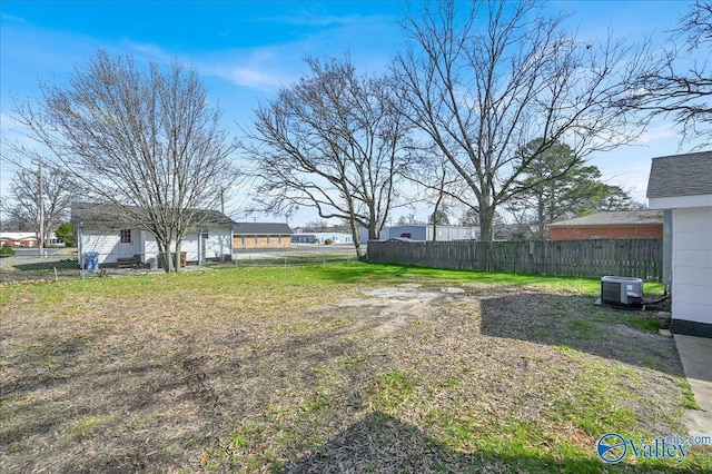 view of yard featuring central AC and fence