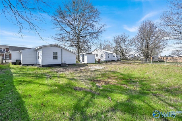 view of yard with a storage shed, fence, and an outdoor structure