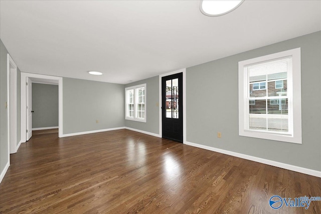 interior space with baseboards and wood finished floors