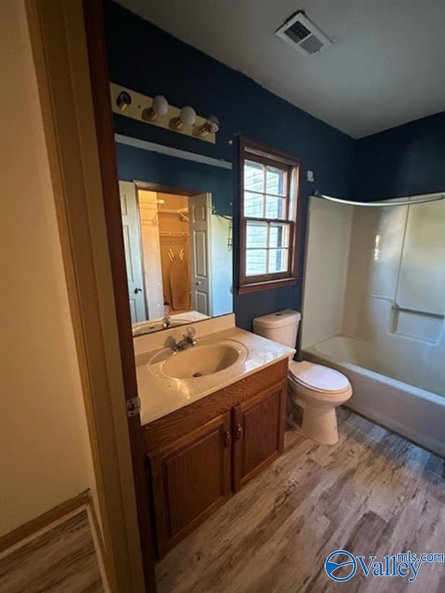 full bathroom featuring toilet, vanity, hardwood / wood-style floors, and bathtub / shower combination