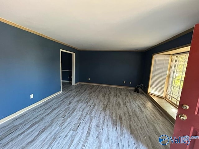 spare room with ornamental molding and hardwood / wood-style flooring