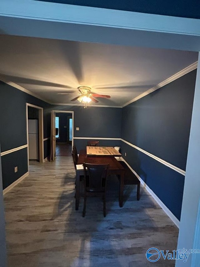 dining space with dark hardwood / wood-style flooring, ornamental molding, and ceiling fan