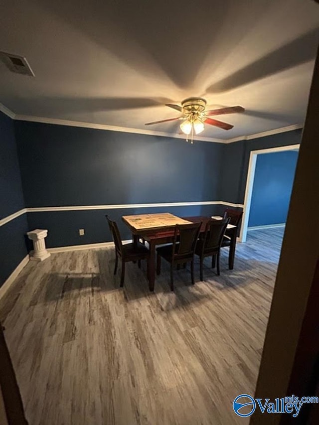 dining room with ceiling fan, crown molding, and wood-type flooring