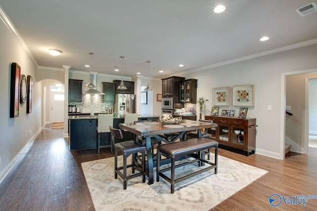 dining area with ornamental molding and hardwood / wood-style floors