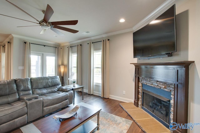 living room with crown molding, a fireplace, and hardwood / wood-style flooring