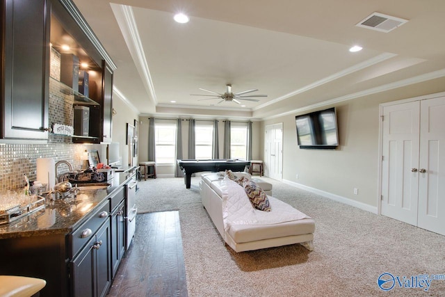 carpeted living room with ornamental molding, sink, billiards, a raised ceiling, and ceiling fan