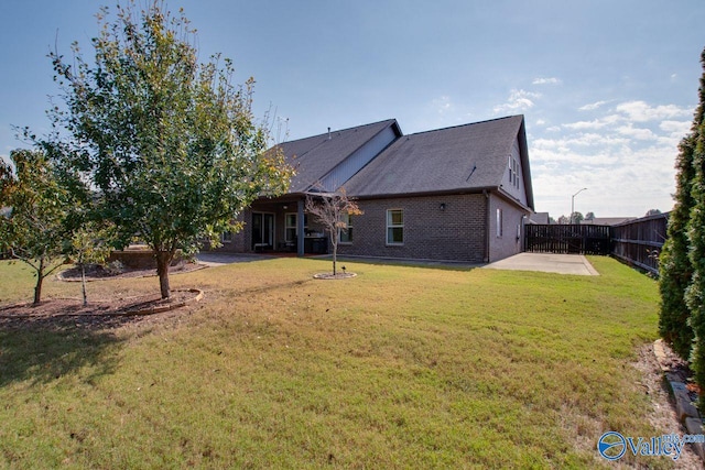 back of property with a patio and a yard