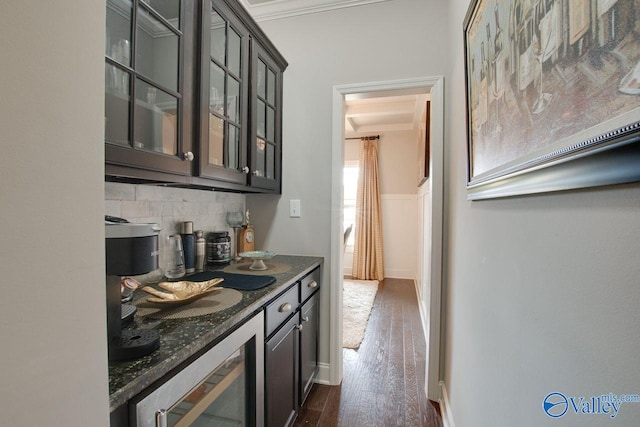 bar with dark stone counters, crown molding, beverage cooler, dark hardwood / wood-style flooring, and tasteful backsplash