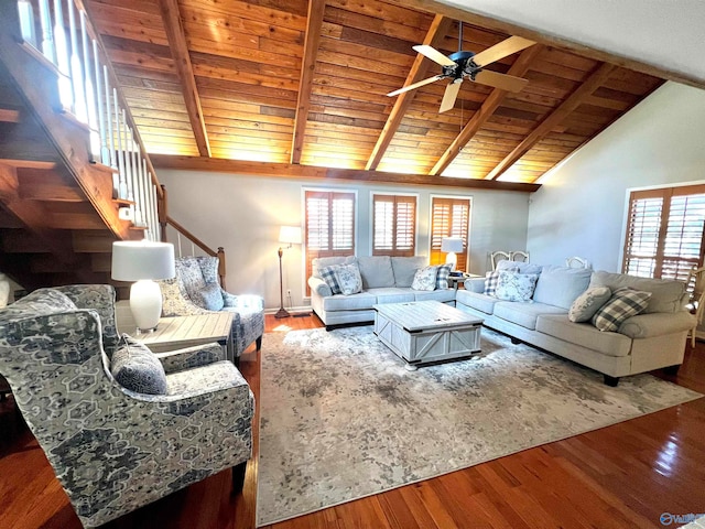 living room featuring a healthy amount of sunlight, vaulted ceiling with beams, and hardwood / wood-style floors