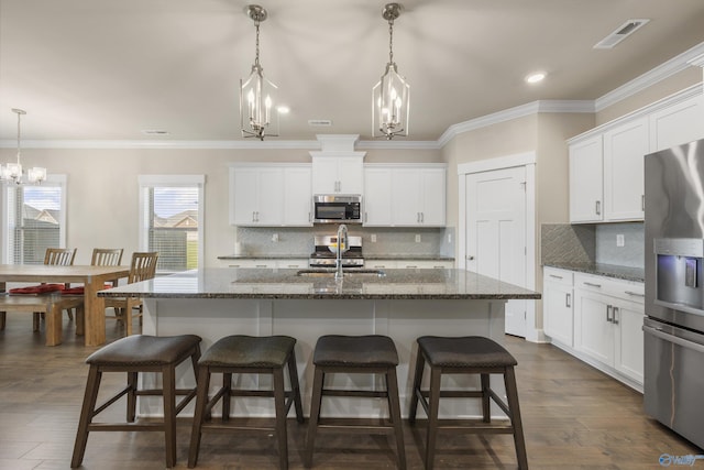 22584 Big Oak Dr, Athens, AL 35613 - kitchen with stainless steel appliances, a sink, tasteful backsplash, visible vents, and a breakfast bar area