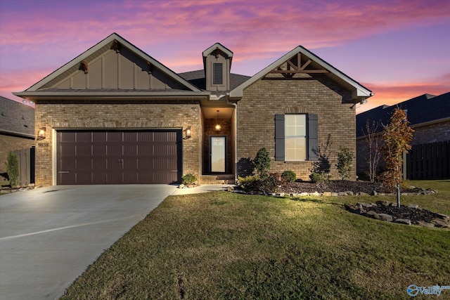 craftsman-style home featuring an attached garage, brick siding, a yard, driveway, and board and batten siding