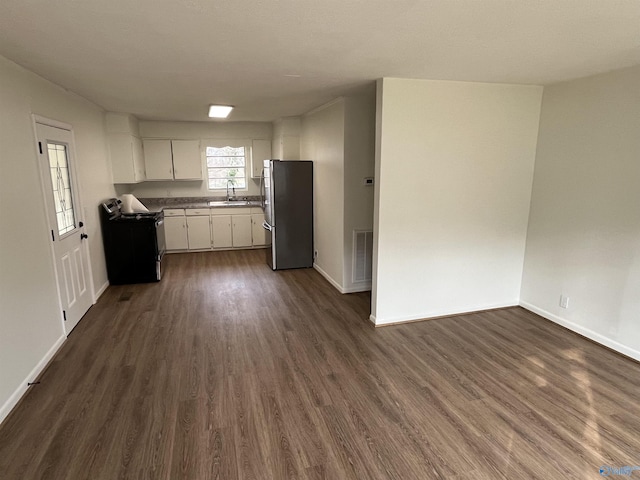 kitchen with dark wood-type flooring, appliances with stainless steel finishes, sink, and white cabinets