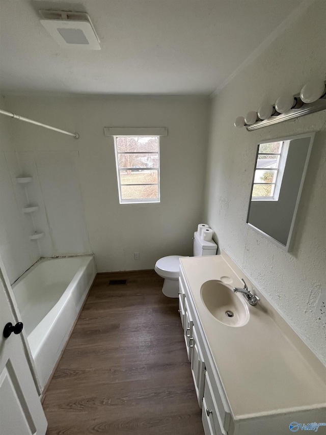 full bathroom with washtub / shower combination, wood-type flooring, toilet, and vanity