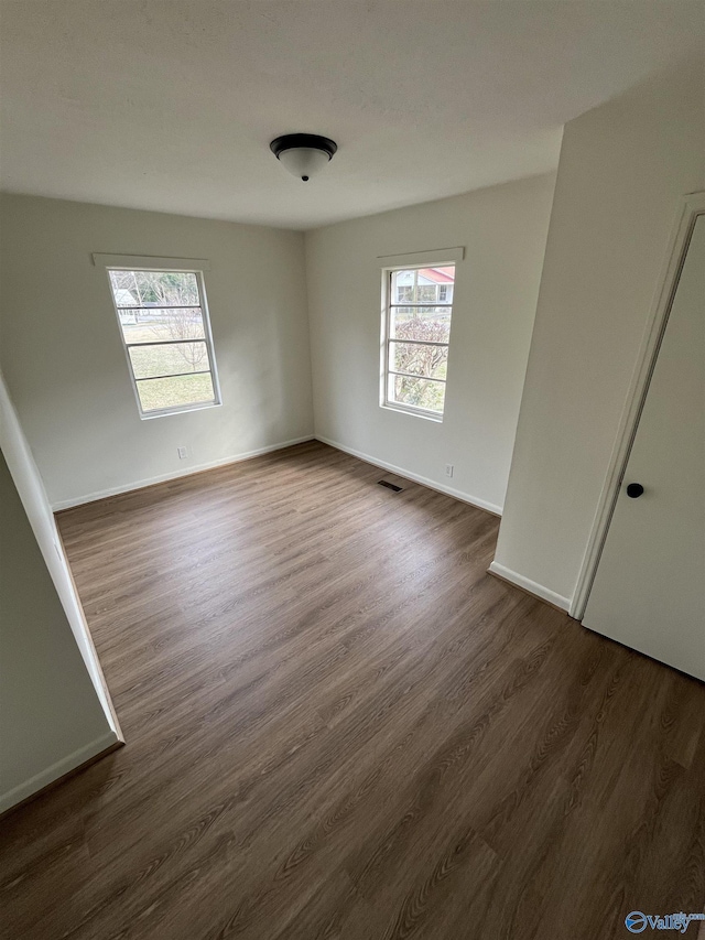 unfurnished room with dark wood-type flooring