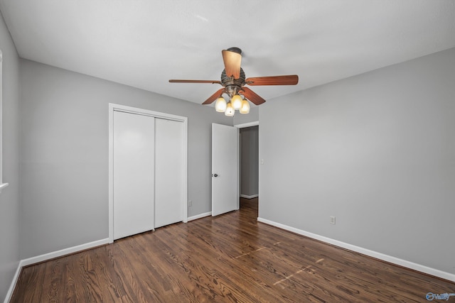 unfurnished bedroom with dark hardwood / wood-style flooring, a closet, and ceiling fan