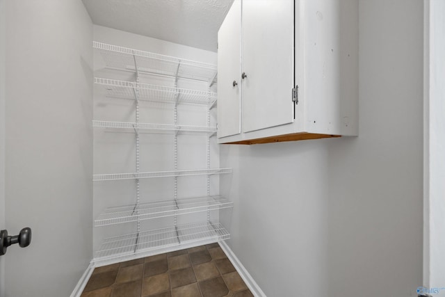 spacious closet featuring dark tile patterned flooring