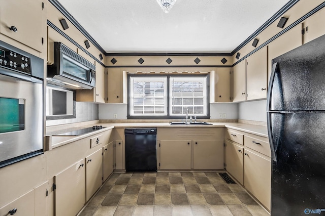 kitchen featuring a textured ceiling, crown molding, sink, black appliances, and cream cabinets