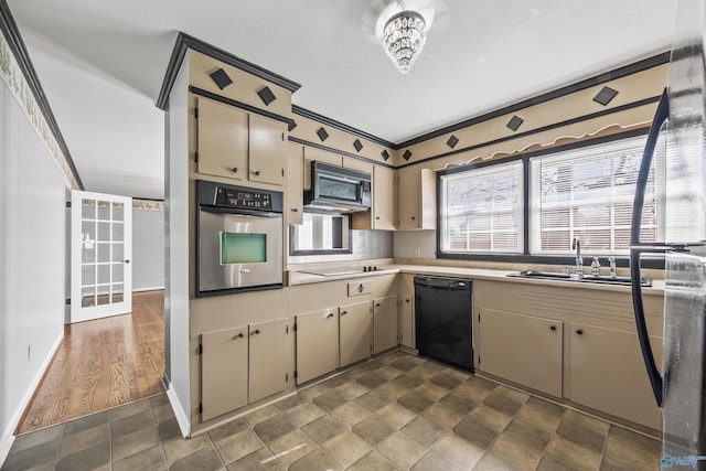 kitchen with cream cabinetry, sink, dark wood-type flooring, and black appliances