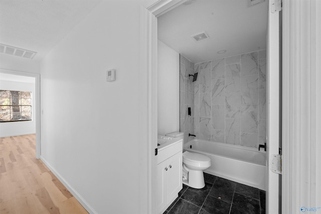 full bathroom with tiled shower / bath combo, vanity, and toilet