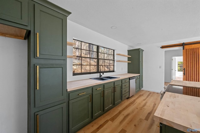 kitchen featuring dishwasher, a barn door, sink, and green cabinets