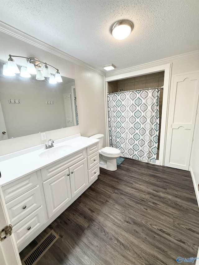 bathroom with vanity, a textured ceiling, hardwood / wood-style flooring, and crown molding