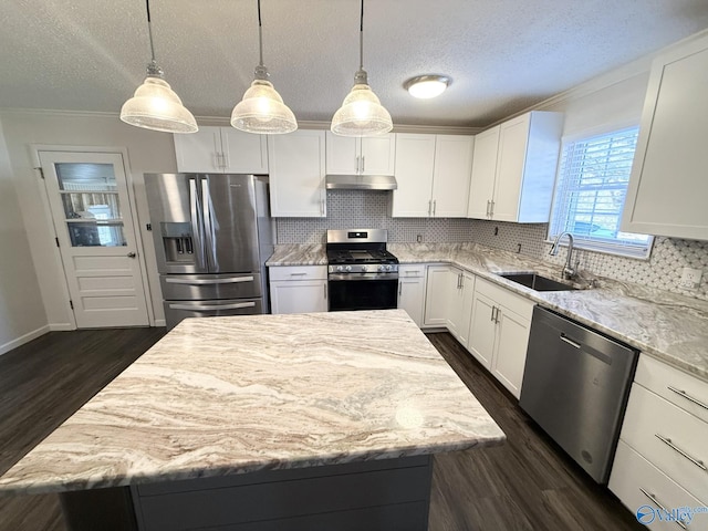 kitchen featuring sink, hanging light fixtures, a kitchen island, white cabinetry, and stainless steel appliances