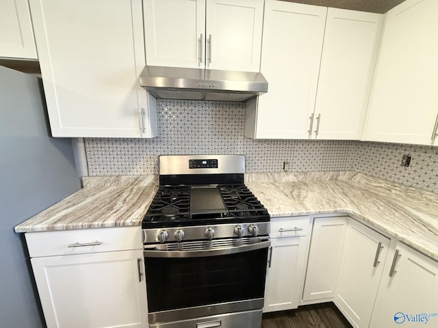 kitchen with white cabinets, backsplash, stainless steel range with gas cooktop, and light stone countertops