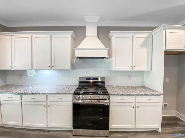 kitchen with custom exhaust hood, light stone counters, stainless steel range with gas stovetop, and white cabinetry