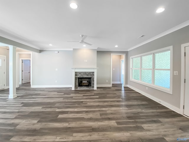 unfurnished living room featuring ornamental molding, dark wood-type flooring, a fireplace, and ceiling fan