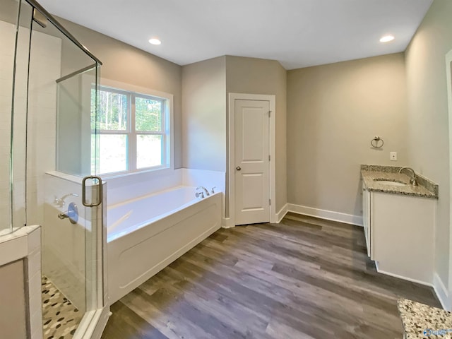 bathroom with plus walk in shower, wood-type flooring, and vanity